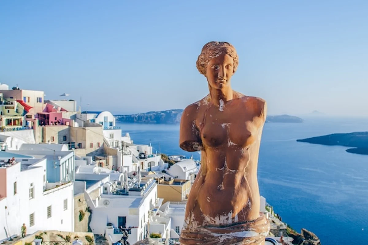Posąg Wenery Miloskiej na Santorini z morzem i grodem w tle
