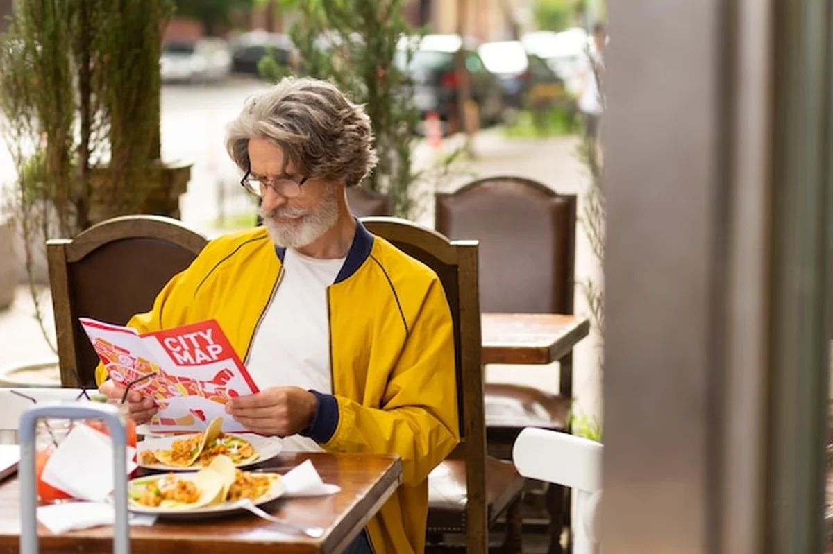 Mężczyzna w ulicznej kawiarni skupiony na mapie miasta