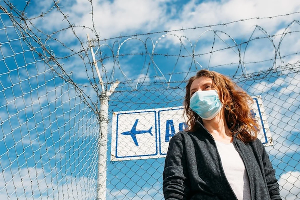 Kobieta na tle nieba przez ogrodzenie