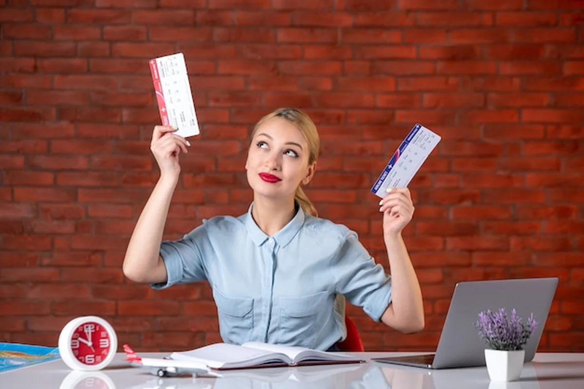 Osoba w biurze podróży trzymająca bilety lotnicze i mapę turystyczną