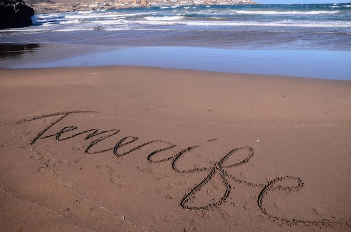 Słowo napisane na piasku na tropikalnej plaży