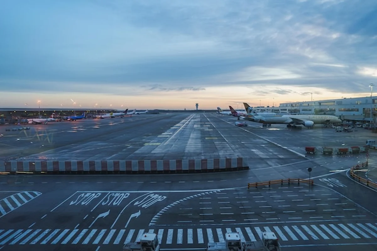 Pas startowy i obszar terminalu lotniska o świcie lub zmierzchu z zaparkowanymi samolotami