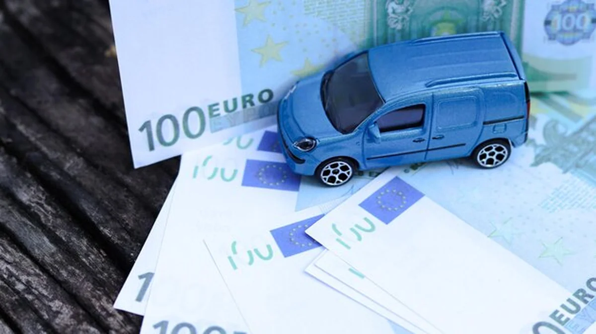 Model samochodu z banknotami euro na tle